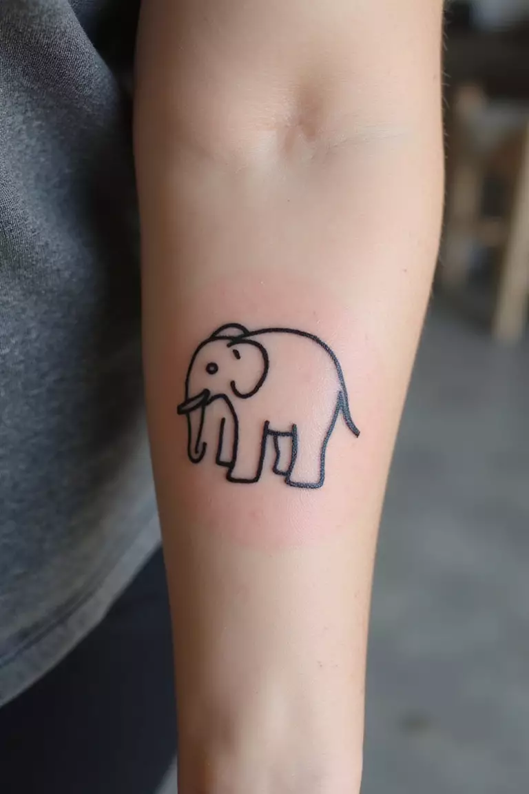 Elephant A close-up shot of a woman's arm with a black ink tattoo of a small, simple elephant outline.