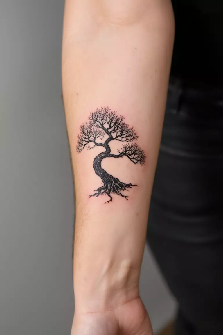 A close up shot of woman's arm with a black ink minimalist bonsai tree silhouette tattoo  