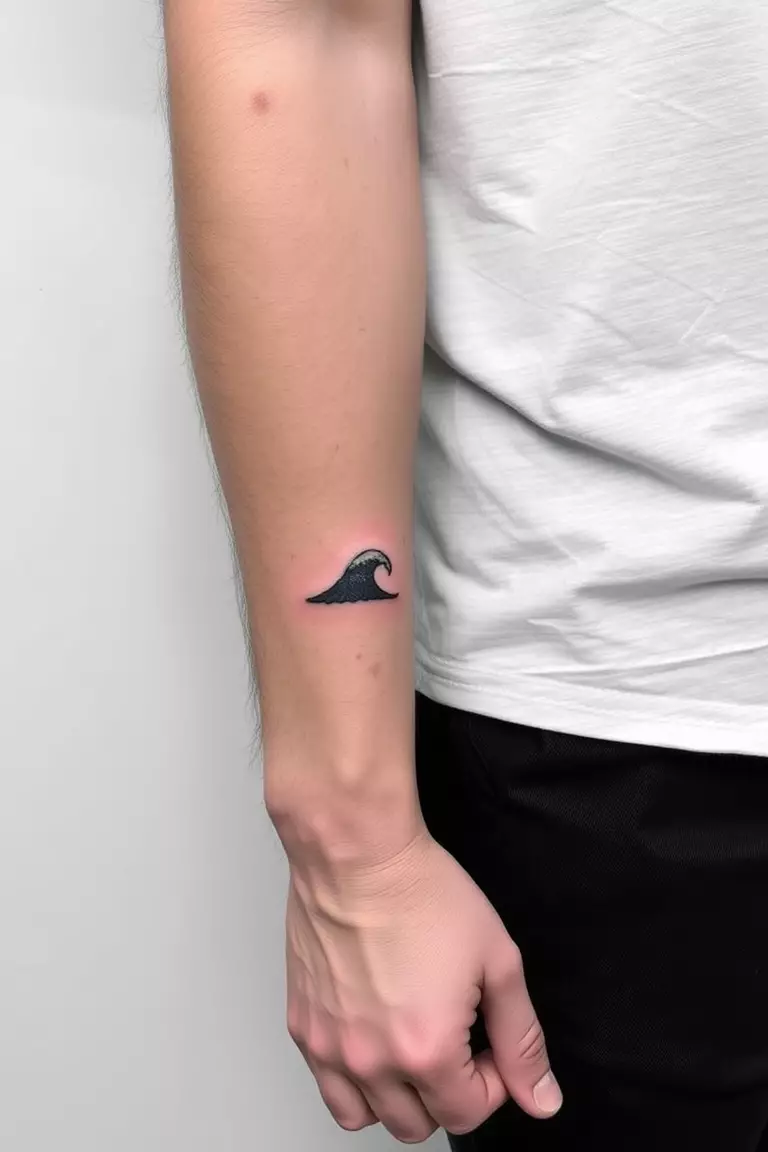 A photo of a man with a minimal wave tattoo on his forearm.  