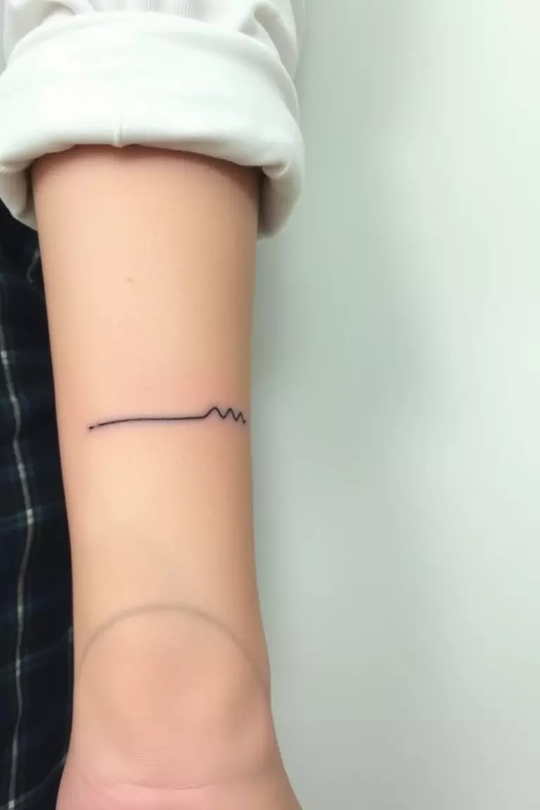 A photo of a woman with a single line wave tattoo featuring shading on her wrist.  