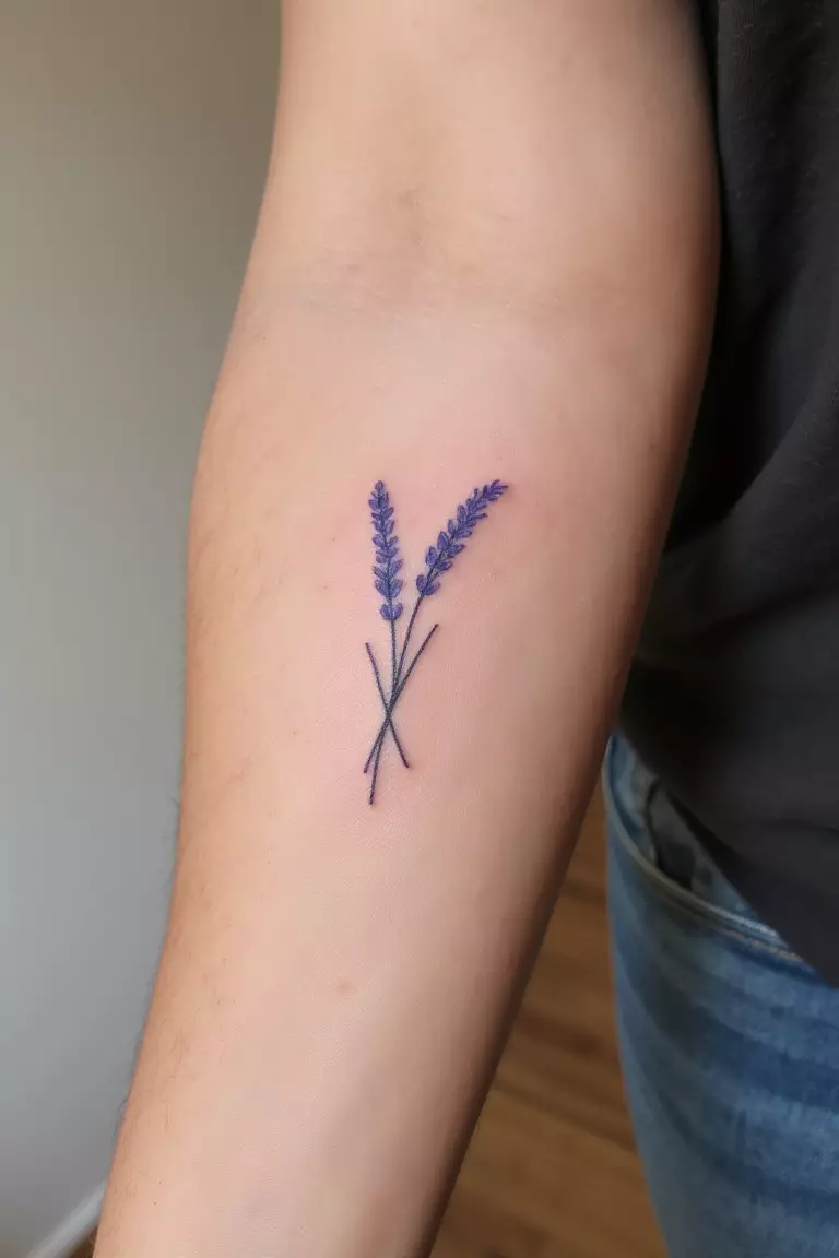 A close up shot of woman's arm with a minimalist lavender silhouette tattoo  