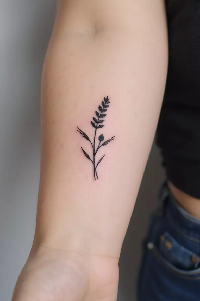 A close-up shot of a woman's arm with a black ink tattoo of a single minimalist flower, like a lavender sprig or a simple daisy, fine line.