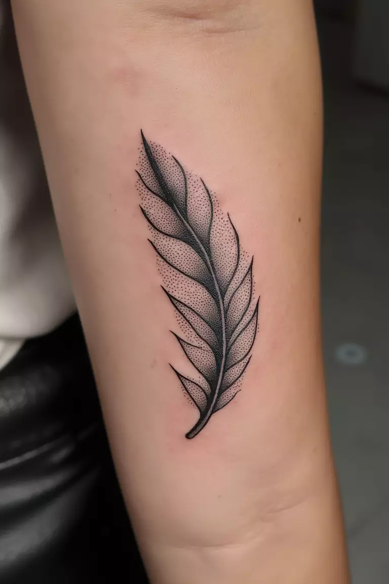 A close up shot of woman's arm with a black ink stippled feather tattoo, created entirely with tiny dots