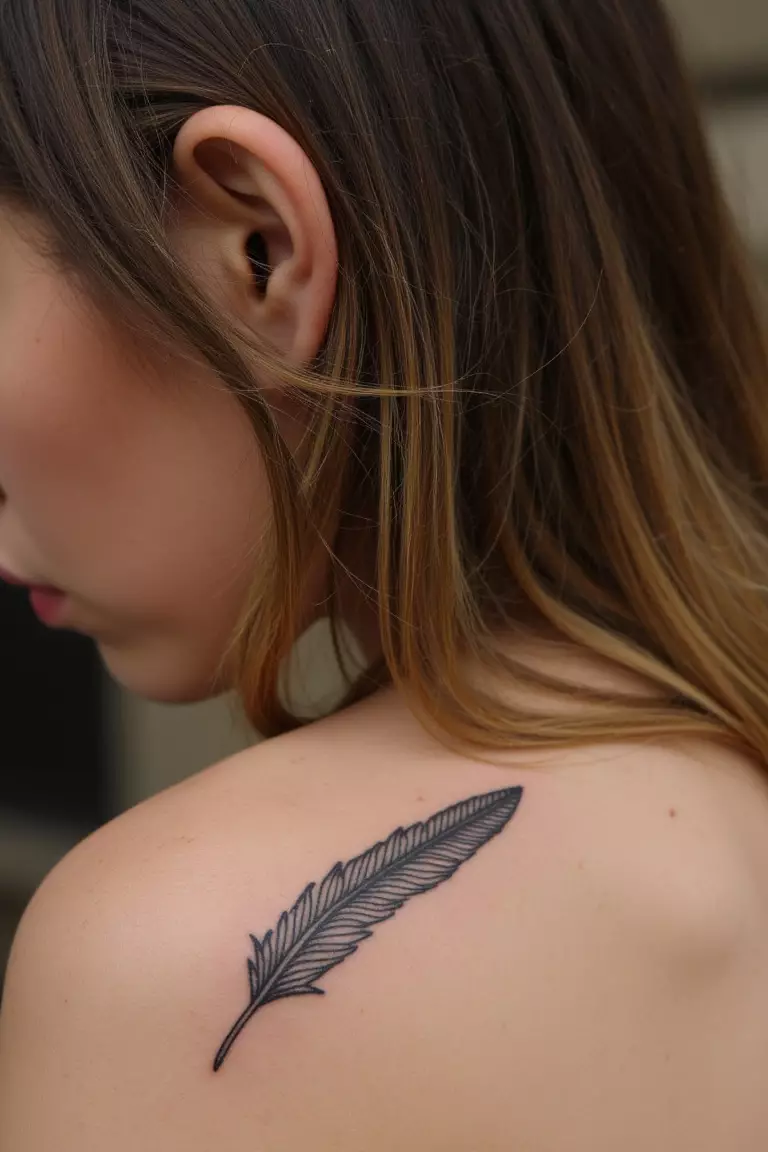 A close up shot of woman's arm with a black ink tiny feather behind ear tattoo, delicate placement peeking from hairline