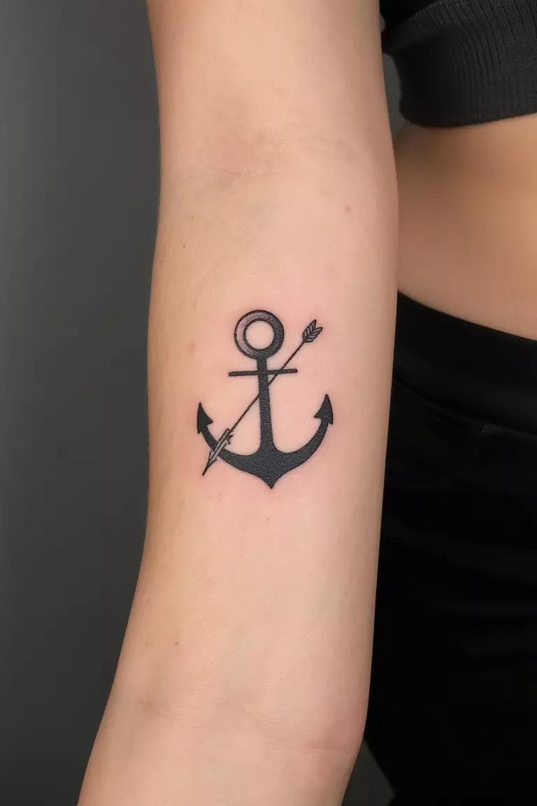 Minimalist Anchor with Arrow A close up shot of woman's arm with a black ink minimalist anchor with arrow tattoo.